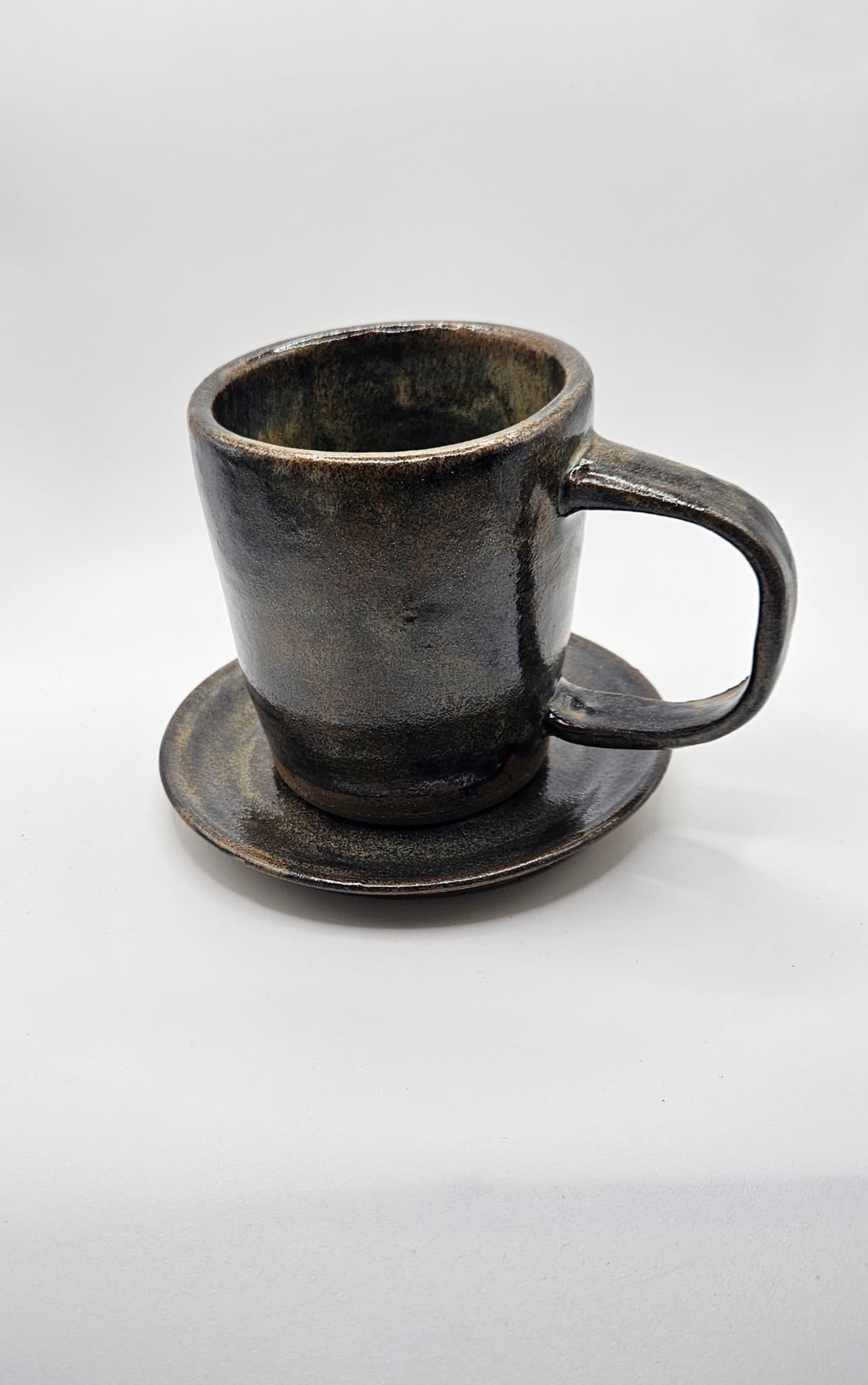 Dark glazed stoneware mug and saucer
